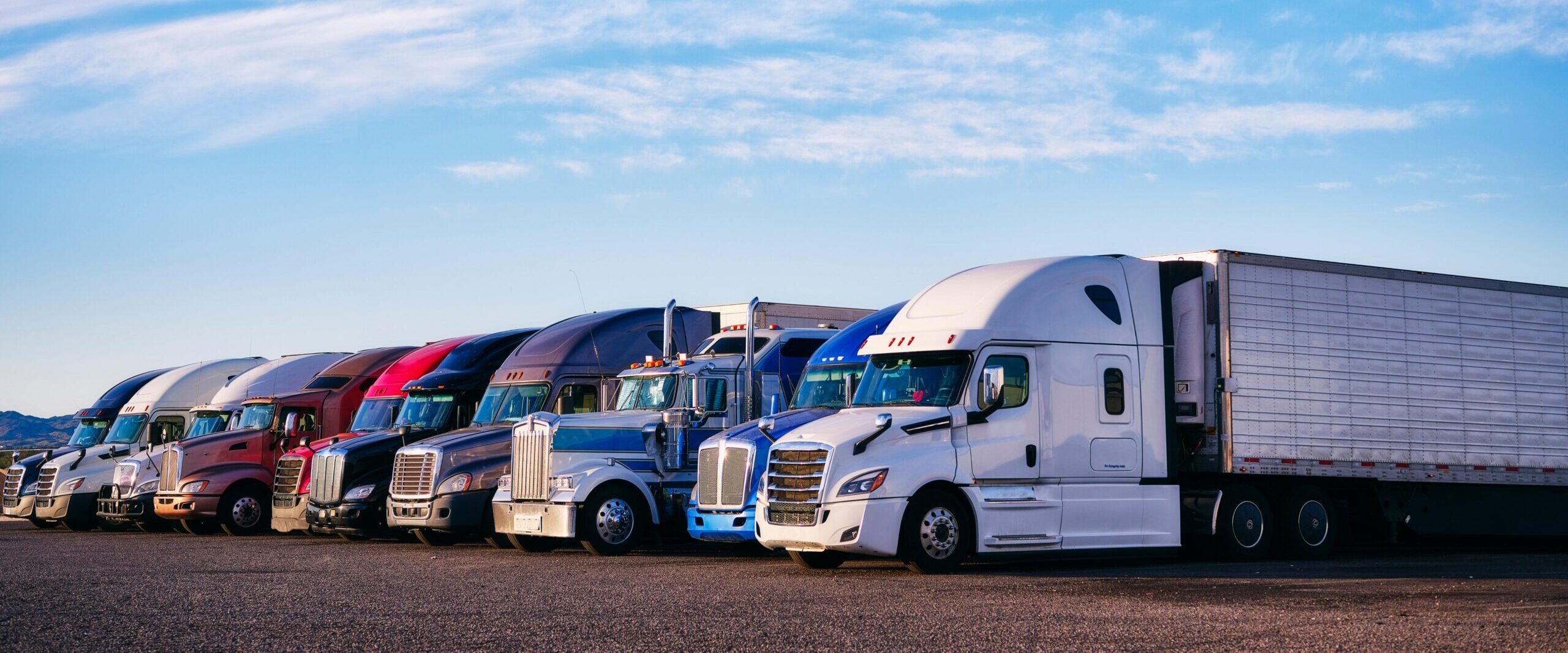 Trucks in front of a blue sky with clouds